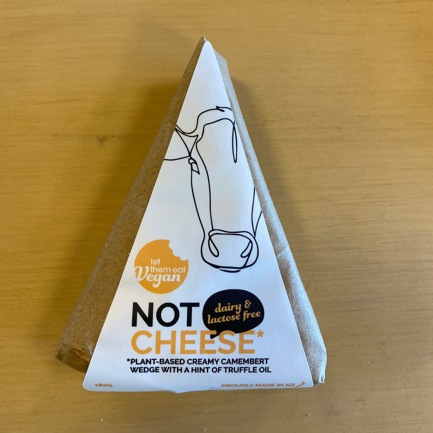 Let Them Eat Vegan Camembert Wedge on a wooden surface