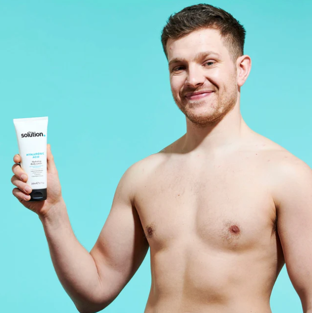 Hot guy holding a tube of 'solution' against a teal background