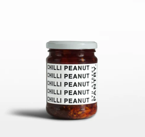 Jar of Chilli Peanut spread with a white label on a light gray background