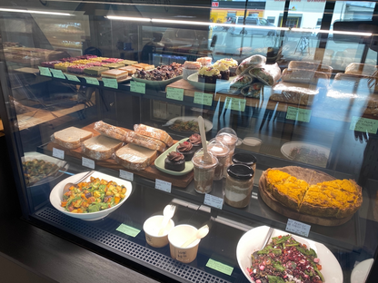 PBCafe cabinet displaying vegan food including salads, pumpkin & vegan bacon pie, gourmet toasted sandwiches and sweet treats. salads and enire top shelf are gluten free