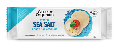 A package of Ceres Organics Brown Rice Crackers Original 115g. The packaging is predominantly white and blue with an image of the crackers and sea salt on the front.