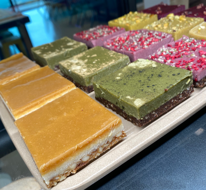 a selection of gluten free trets including salted caramel, atcha, raspberry & hemp, and ginger pistachio