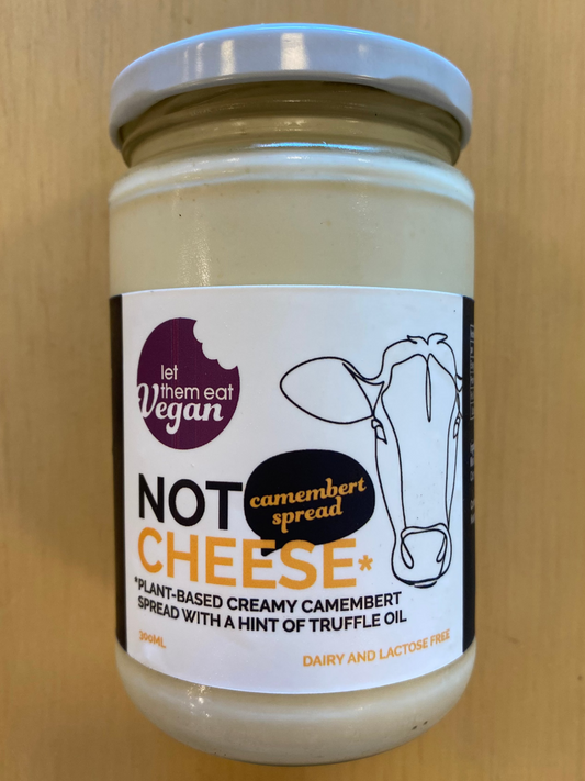 Jar of Let Them Eat Vegan Camembert Spread with a label on a wooden background