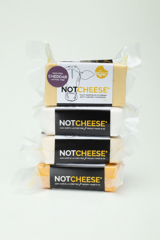 Stack of Let Them Eat Vegan Cheddar Blocks with packaging on a white background