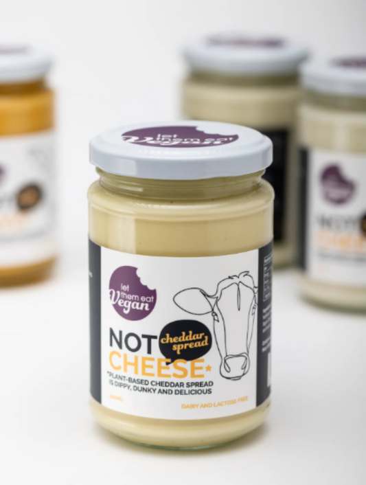 Jar of Let Them Eat Vegan Cheddar Spread with a visible brand label on a white background