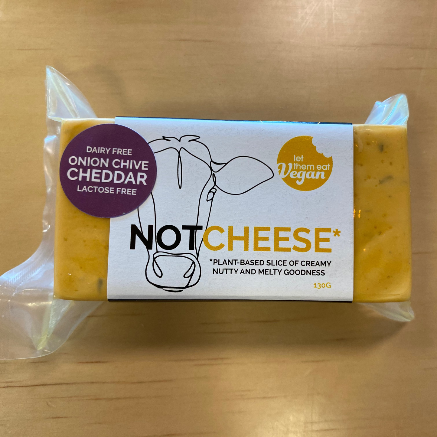 Let Them Eat Vegan Onion and Chive Cheddar Block on a wooden background