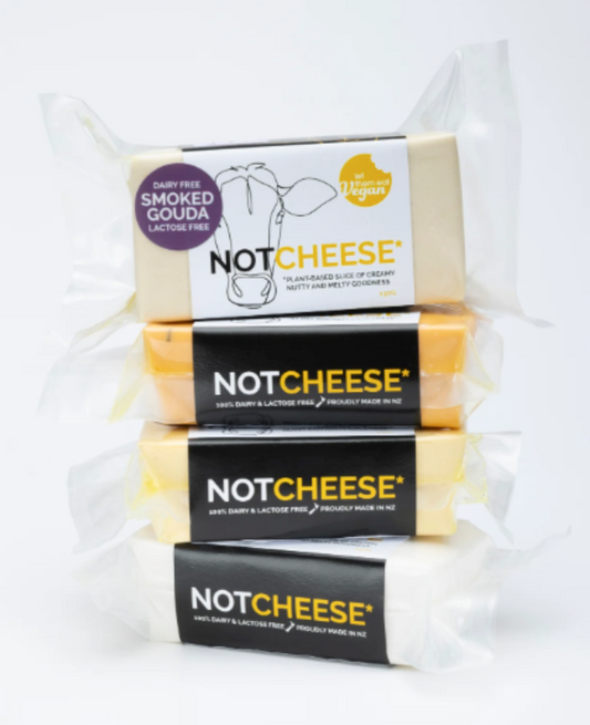 Stack of Let Them Eat Vegan Smoked Gouda Blocks with visible branding on a white background