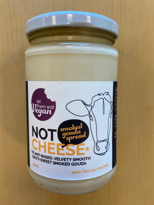 Jar of Let Them Eat Vegan Not Cheese Smoked Gouda spread with a label on a wooden background