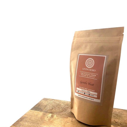Kraft paper packaging of LIVING KOKO cacao on a wooden surface with a white background