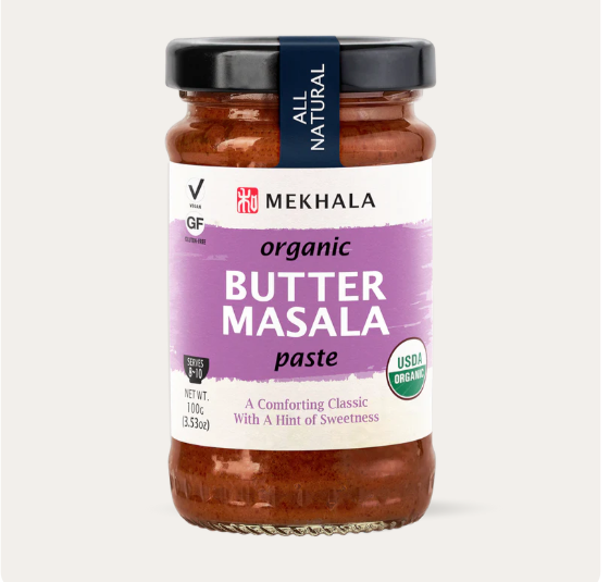Jar of Mekhala organic butter masala paste on a light beige background
