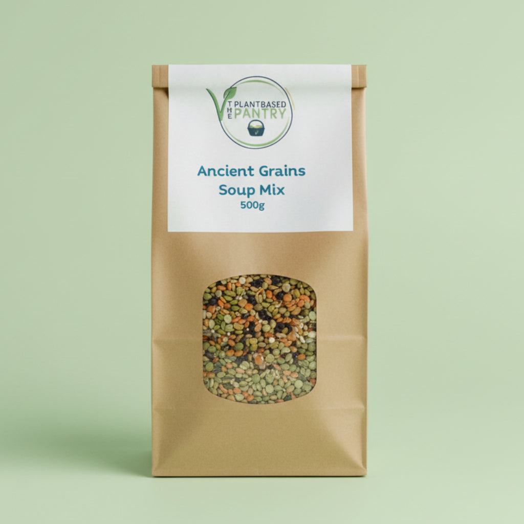 A 500g paper bag of Plant Based Pantry Ancient Grains Soup Mix, featuring a clear window showing the mixed grains inside, set on a wooden surface.