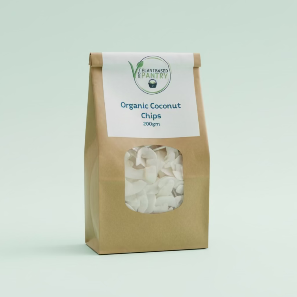 A 200g bag of PlantBased Pantry Organic Coconut Chips on a wooden table, with a brown kraft paper bag and a white label.