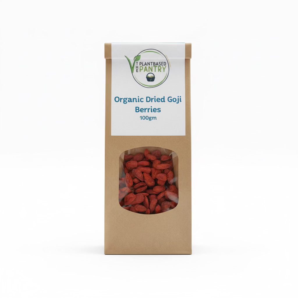A 100g paper bag of PlantBased Pantry Organic Dried Goji Berries, displayed on a wooden surface. The kraft paper bag features a white label with blue text and a clear window showing the dried red-brown berries inside.