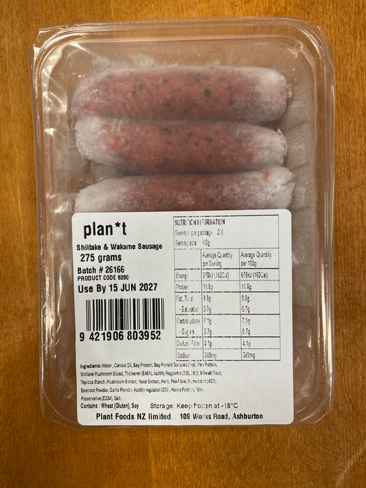 A 275g package of Plan*t Skillet & Wok Sausage in a clear plastic clamshell container with a white nutrition label, placed on a wooden surface.