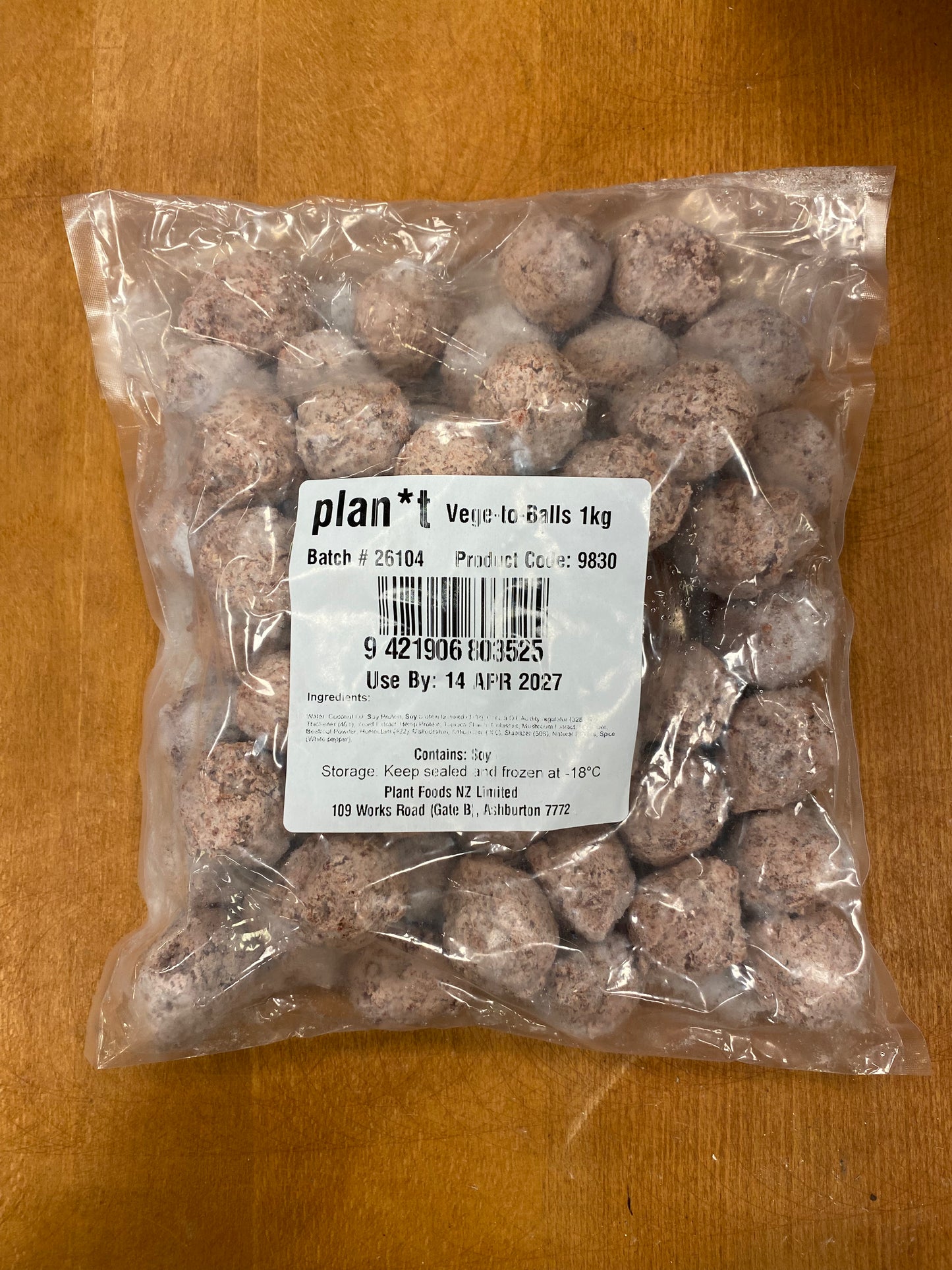 A clear plastic bag filled with round, speckled beige and brown freeze-dried plant food galls, with a white label reading 'plan** Veseic Galls 1kg', placed on a wooden surface.