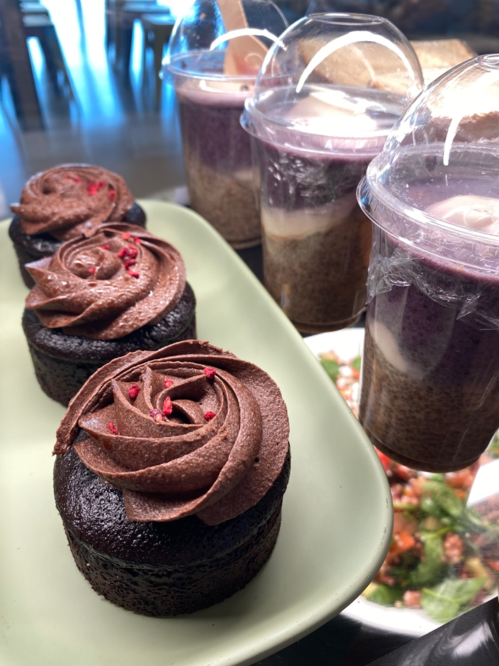 individual vegan chocolate mud cake and apple & blackcurrant crumble chis pudding with vegan custard