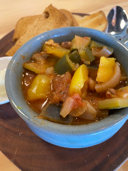 a bowl of PBCafe hearty began tuscan soup served with sourdough or gluten free toast and vutter